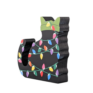 3/4" thick wooden replica of a black cat with a green beanie on all tangled up in christmas lights