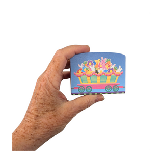 Hand holding a colorful wooden replica with cartoon design on a white background