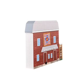 3/4" thick wooden illustration of a model of a red mill with a flag quilt design above the entrance labeled 'Four Flags Grist Mill'.