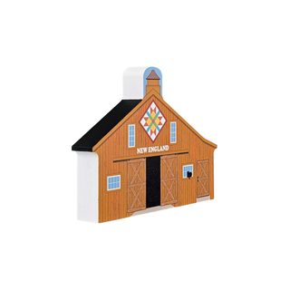 3/4" thick wooden replica with an illustration of a New England barn figurine with a brown wood-grain finish, black roof, colorful quilt pattern, and 'NEW ENGLAND' text on the front, shown on a plain white background.