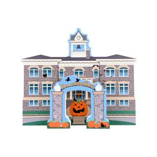 A die-cut Halloween schoolhouse decoration featuring a gray brick building with blue trim, a central arch with pumpkins, bats, and the word 'Halloween,' plus small black cats on the lawn.