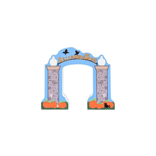 3/4" thick wooden replica of A Halloween-themed arch with the words 'Halloween Village' in gold lettering. The design features a light blue sky background, stone pillars, black crows, orange pumpkins, and a small black cat on a white background.