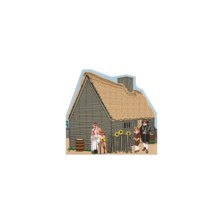 3/4" wooden replica with an illustration  of a thatched-roof house with people outside on a white background