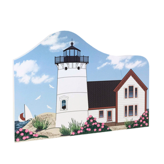 wooden replica with a Lighthouse and house with a sailboat and flowers on a blue sky background