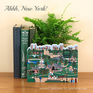 Wooden Central Park keepsake with books and a plant on a wooden surface.