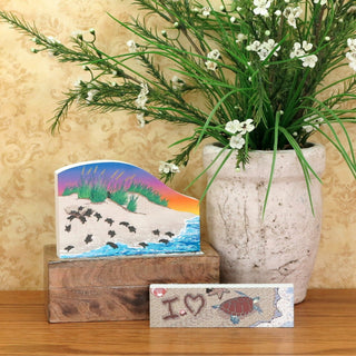 Decorative items including a vase with greenery, a small painting, and a wooden block with 'I love' text on a wooden surface.