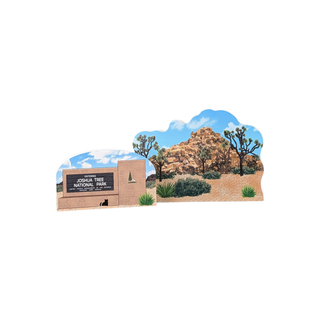 3/4" thick wooden illustration of a desert landscape with rocky outcrop, Joshua trees, and shrubs and a sign on a white background