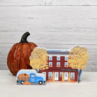Decorative set with a pumpkin, 3/4" thick wooden miniature house on a wooden surface.