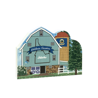 3/4" thick wooden  of a barn with 'Celebrate America Idaho' text and a flag on a white background
