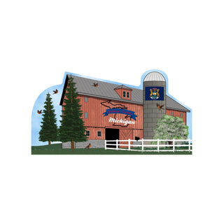 Red barn with 'Celebrate America Michigan' sign, trees, and a silo on a blue background