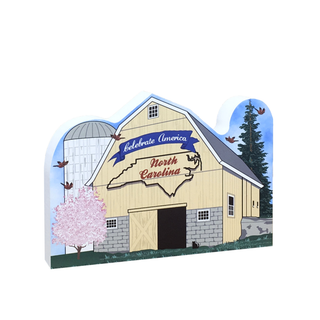 3/4" thick wooden cutout with a barn design featuring 'Celebrate America North Carolina' text, trees, and birds.
