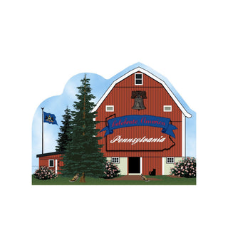 3/4" thick wooden cutout of a Red barn with 'Celebrate America Pennsylvania' banner, trees, and flowers on a blue sky background