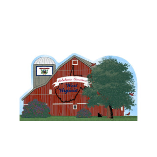 3/4" thick wooden cutout of a Red barn with West Virginia design and American flag on a blue background