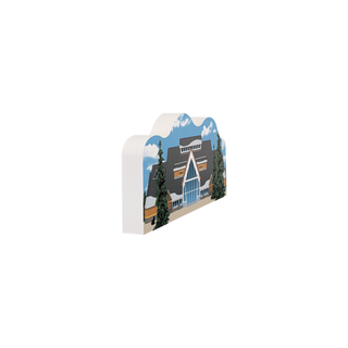 3/4" wooden replica with an illustration of a large building with big windows and yellow siding with snow and trees 