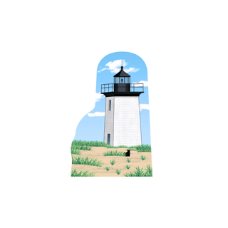 wooden replica of a lighthouse with a blue cloudy sky and beach