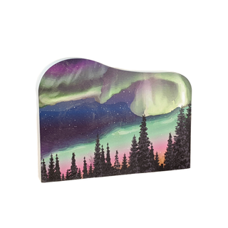 wooden replica with a design of the Northern Lights over trees