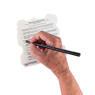 Hand holding a pen over a Yellowstone National Park map with checkboxes.