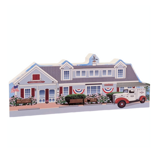 wooden replica of a house with a vintage truck in front 