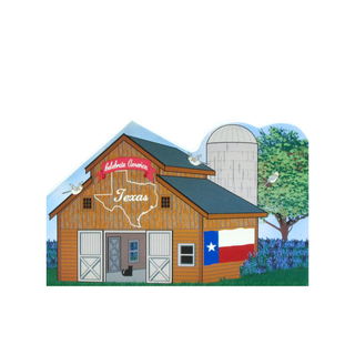 3/4" thick wooden cutout of a Wooden barn with Texas design, including a map of Texas and the state flag, with a blue sky background.