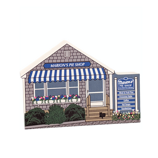 wooden replica  of Marion's Pie Shop with a blue and white striped awning and sign.