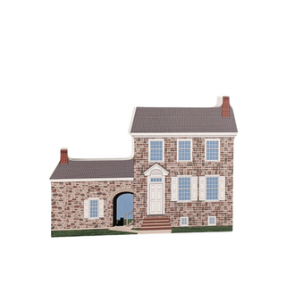 3/4" thick wooden cutout  of a stone house with a white door and blue windows on a white background