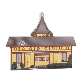 wooden replica of a building labeled 'Chatham Railroad Museum' with a gray roof and yellow walls.