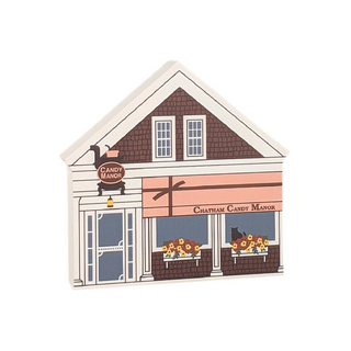 Wooden replica of a candy store with 'Chatham Candy Manor' branding on the front and flowers