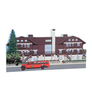 3/4" thick wooden illustration of a building with a red bus in front on a white background