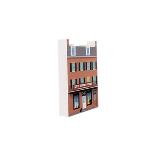 3/4" thick wooden illustration of a dry goods store with a red sign and windows displaying items.