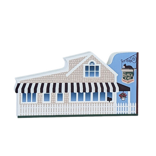 Wooden replica of a beach house with a black and white striped awning on a white background for the black cat restaurant 