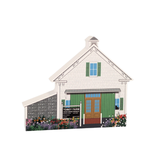 3/4" thick wooden Model of a barn with 'Tobey Farm' on the door, surrounded by flowers and plants.