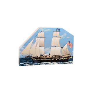 3/4" thick wooden cutout of aWooden ship model with American flag on a blue ocean background