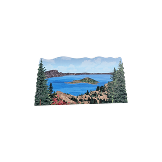3/4" wooden cut out replica of an illustration of a mountain lake scene with trees and mountains.
