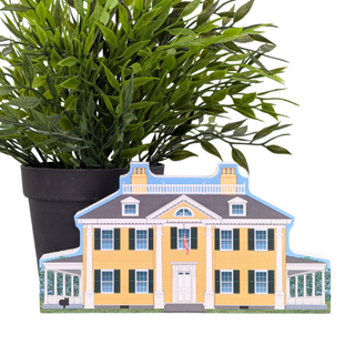 3/4" wooden replica with an illustration of a yellow 2 story house with a plant pot on a white background