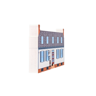 3/4" thick wooden replica with an illustration of atwo-story house with white siding, blue shutters, a dark gray roof, and brick trim, photographed on a plain white background.