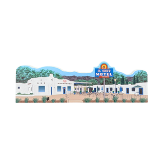 3/4" thick wooden replica with an illustration of  El Vado Motel in Arizona, with white motel buildings, blue sky, green trees, and a blue signpost, shown on a plain white background.