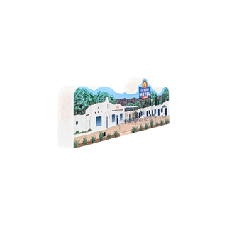 3/4" thick wooden replica with an illustration of a painted scenic illustration of a white building with blue doors, green trees, mountains, and a blue sign reading 'El Moro Water'.
