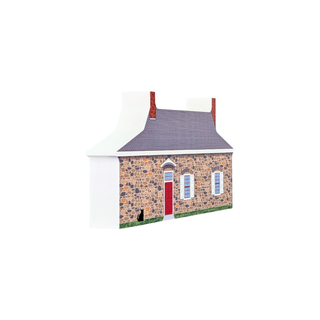 3/4" thick wooden replica with an illustration of a a gray roof, tan and brown stone facade, red door, white walls, and green grass, shown on a plain white background.
