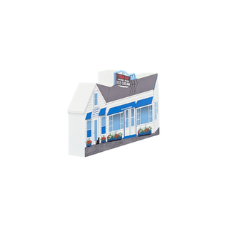 3/4" thick wooden replica with an illustration of a white and blue house-shaped model building with a gray roof, detailed storefront windows, flower boxes, and a small sign reading 'The Creamery Ice Cream', shown on a plain white background.