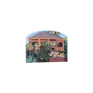 3/4" wooden replica with an illustration  of a gazebo with a bicycle and plants on a white background