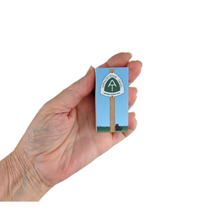 Hand holding a small 3/4" thick wood Appalachian Trail box with a blue sky and green landscape design.