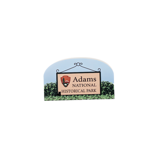 3/4" wooden replica with an illustration of a Sign for Adams National Historical Park with a blue sky and greenery background