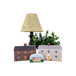 Decorative lamp with a house model and plant on a white background