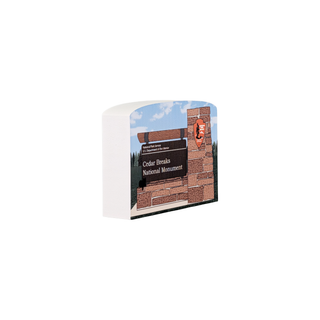 3/4" wooden replica with an illustration of a scenic design of a brick building and trees on a white background