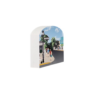 3/4" thick wooden illustration of a street scene with palm trees and people.