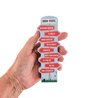 Hand holding a small 3/4" thick wooden replica with an illustration with street names of Ohio State University on a white background