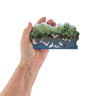 Hand holding a 3/4" thick wooden illustration of birds on water on a white background