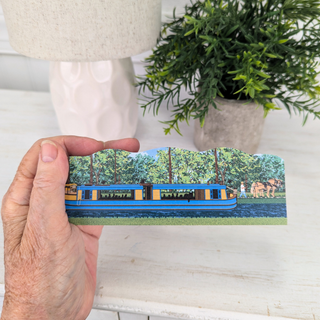 Hand holding a 3/4" thick wooden illustration of a canal boat