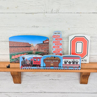 Collection of Ohio State-themed items including a stadium view, train, and letter 'O' on a wooden shelf.