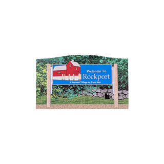 3/4" thick wooden replica with an illustration of a 'Welcome To Rockport' with a red barn illustration, mounted on two posts against a white background.